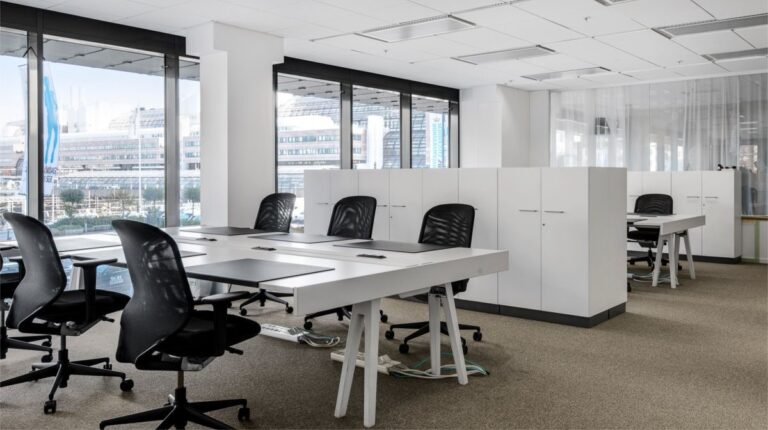 Ruang kantor modern minimalis dengan pencahayaan alami dan tanaman hijau indoor hasil desain interior profesional.