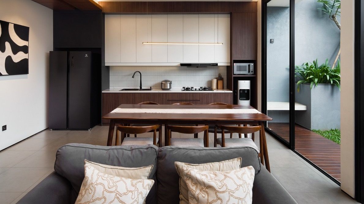 Hasil renovasi ruang tamu cantik dengan cat dinding netral dan pencahayaan estetik.